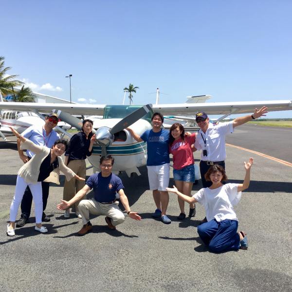 group of people with pilot in front of plane