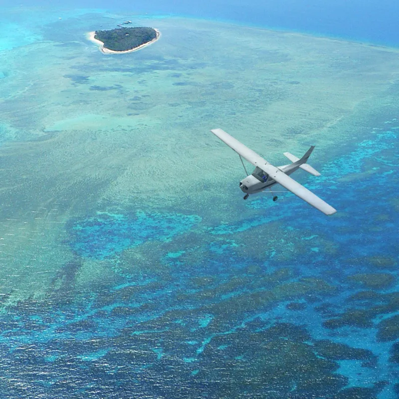 plane flying over reef